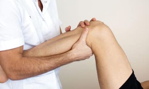 the doctor examines the knee for arthrosis